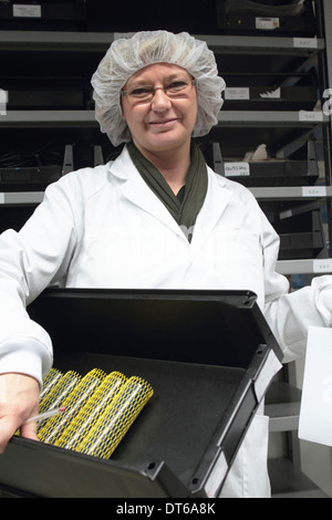 Donna scienziato vassoio di trasporto in laboratorio laser Foto Stock