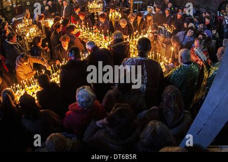 Blagoevgrad, Bulgaria. 10 Febbraio, 2014. Il 10 febbraio, la Chiesa Ortodossa Bulgara celebra il giorno di San Haralambos il martire, che è anche venerato come patrono di tutti gli apicoltori, giardinieri e frutta-coltivatori. I fedeli accendono le candele con vasetti di miele durante una Santa Messa per il 'sanctification di miele'' a ''la Presentazione della Beata Vergine " chiesa cattedrale della città di Blagoevgrad, Bulgaria. Il miele è consacrata e quindi tutto il pane è rivestito con esso. Il resto del miele è mantenuto in casa come un rimedio. Credito: Hristo Vladev/NurPhoto/ZUMAPRESS.com/Alamy Live News Foto Stock