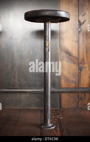 Un alto sgabello da bar da un contatore di legno in un ristorante. Foto Stock