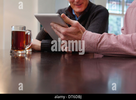 Padre e Figlio con tavoletta digitale in bar Foto Stock