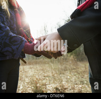 Un paio di cappotti invernali, all'aperto su una giornata invernale e. Tenendo le mani. Foto Stock