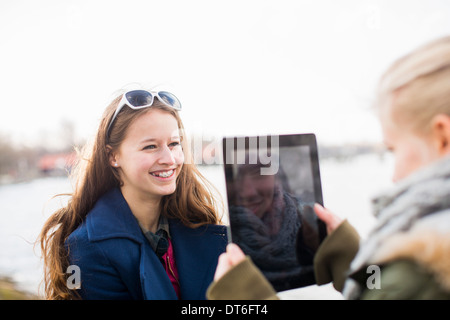 Ragazza adolescente fotografare amico con tavoletta digitale Foto Stock