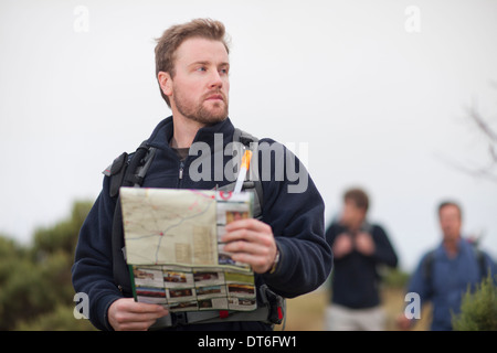 Tre uomini escursionismo con zaini e mappa Foto Stock