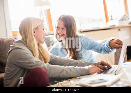 Le ragazze adolescenti utilizzando portatile a casa Foto Stock