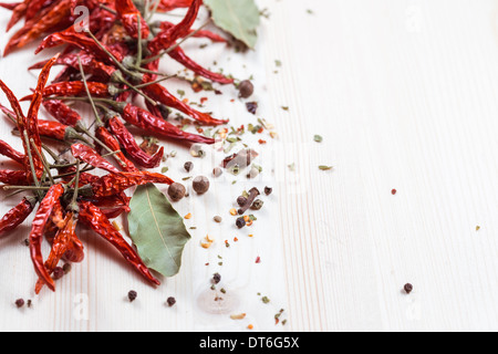 Secchi peperoncino rosso e spezie su tavola in legno rustico Foto Stock