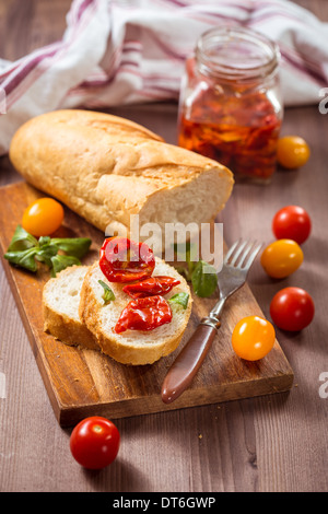 Baguette con pomodori secchi in olio di oliva Foto Stock