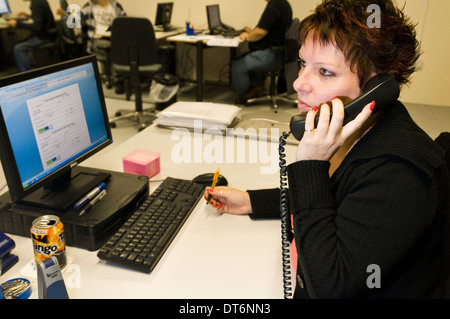 Donna che parla al telefono in un ufficio Foto Stock