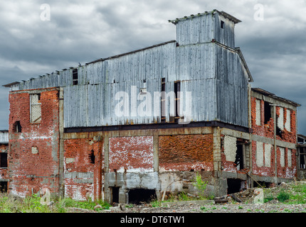 Аbandoned edificio industriale costruito in mattoni rossi in tempo di crisi Foto Stock