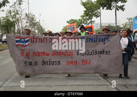 Bangkok, Tailandia. Il 10 febbraio 2014. Gli agricoltori tenere il loro slogan durante un rally al composto di Ministero del Commercio. Coltivatori di riso hanno protestato chiedendo che il governo paga per il loro riso sotto il riso-Regime dei donatori. Il governo ora anche visi arrabbiati gli agricoltori, in quanto essa non è riuscita a sollevare 100 miliardi di baht tailandese (3,1 miliardi di dollari US) che ancora deve a più di un milione di coltivatori di riso che ha acquistato ai primi di ottobre. Credito: Sanji Dee/Alamy Live News Foto Stock