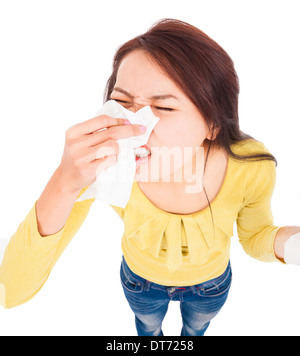 Giovane donna avente allergia e soffiando nel tessuto su bianco Foto Stock