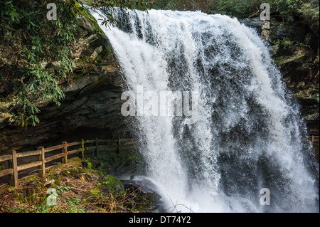 Un sentiero panoramico si snoda sotto una sporgenza di roccia dietro la tenda acquatica di Dry Falls tra Highlands e Franklin, North Carolina. (USA) Foto Stock