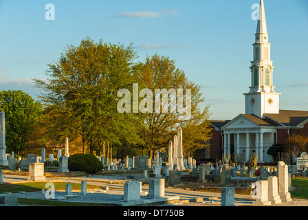 Un sole che tramonta mette in risalto i marcatori e i monoliti del cimitero storico di Snellville e della prima chiesa battista di Snellville, Georgia. (USA) Foto Stock