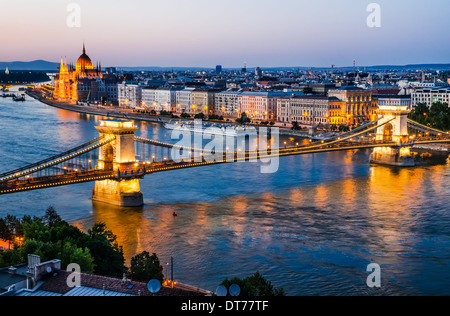 Szechenyi o Chain Bridge è un ponte sul fiume Danubio con Orszaghaz edificio del Parlamento, le luci della notte. Budapest, Ungheria. Foto Stock