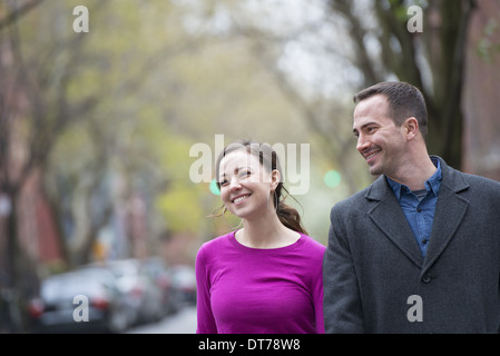 Una coppia di uomo e donna fianco a fianco su una strada della citta'. Foto Stock