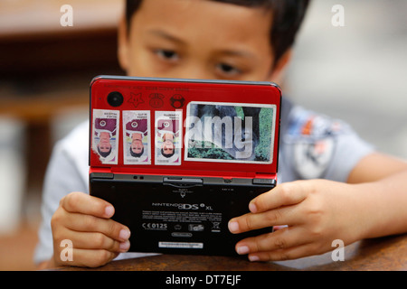 Ragazzo giocando con una console per videogiochi Foto Stock