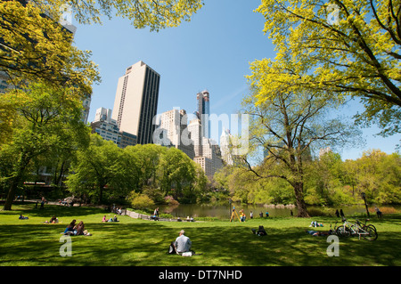 Persone relax presso lo stagno su una soleggiata giornata di primavera nel Central Park di New York City STATI UNITI D'AMERICA Foto Stock