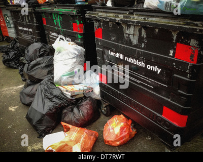 Ruote grandi scomparti per le discariche con traboccante di sacchetti di plastica Foto Stock