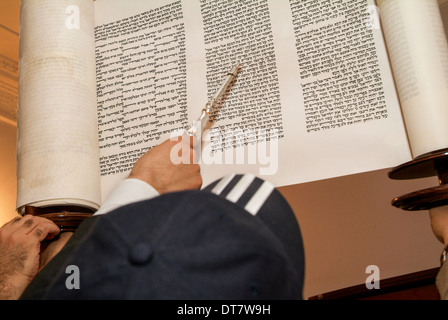 Kabbalah Centre di Londra, Regno Unito. Due uomini che tengono in alto e la lettura da un uso più sicuro di Torah scorrere puntando alla Torah ebraica script, testo. Foto Stock