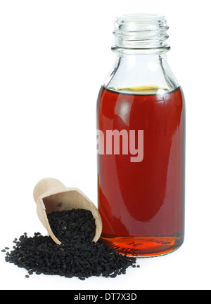 Nigella sativa (cumino nero) sul cucchiaio di legno e di olio essenziale Foto Stock