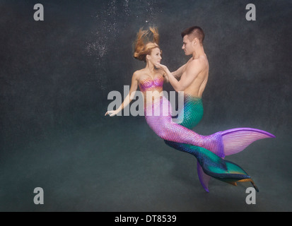 Due merpeople intrecciate sott'acqua in una piscina in Virginia Beach, Virginia. Foto Stock