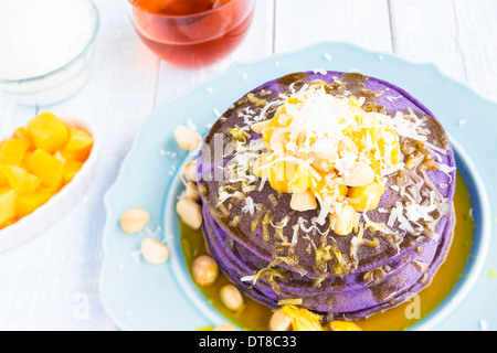 Frittelle di Taro e rabboccato con mango, noci macadamia, cocco grattugiato e sciroppo di lilikoi Foto Stock