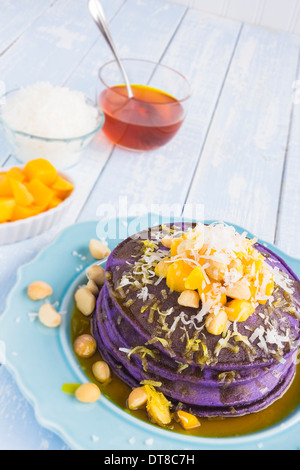 Frittelle di Taro e rabboccato con mango, noci macadamia, cocco grattugiato e sciroppo di lilikoi Foto Stock