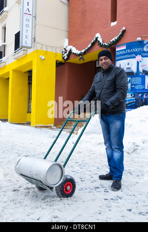 Uomo che porta un barile di birra a Bucarest, Romania Foto Stock