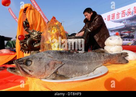 Qingdao, Cina Shandong. 12 feb 2014. Un uomo prepara i sacrifici per rendere omaggio al mare dei e dee nella città di Qingdao, Cina orientale della provincia di Shandong, Feb 12, 2014. © Yu Fangping/Xinhua/Alamy Live News Foto Stock