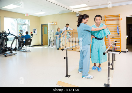 I terapisti assistere i pazienti in ospedale Palestra Foto Stock