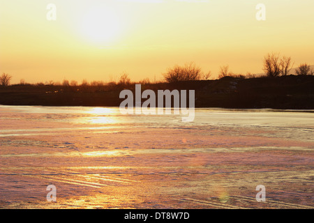 Tramonto su un lago ghiacciato Foto Stock