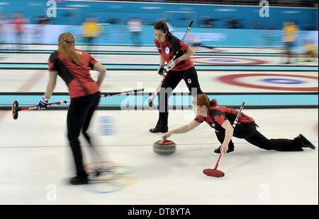 Sochi, Russia. Il 12 febbraio 2014. Alba McEwen (CAN) spinge fuori con Kaitlyn Lawes (CAN, vice saltare, a sinistra) e Jill Officer (CAN). Womens curling - Ice Cube Curling Center - Olympic Park - Sochi - Russia - 12/02/2014 Credit: Sport In immagini/Alamy Live News Foto Stock