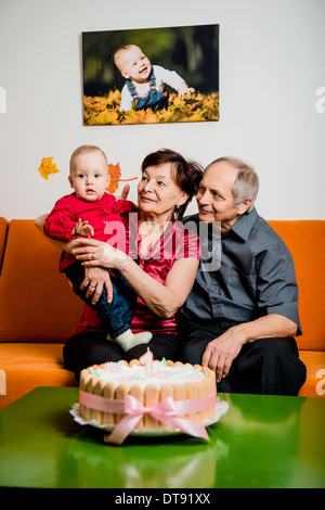 Nonni con il loro piccolo nipote celebrare la prima festa di compleanno a casa Foto Stock