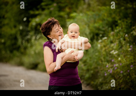 Nonna con il nipote - senior donna mentre tiene il suo nipote outdoor in natura Foto Stock