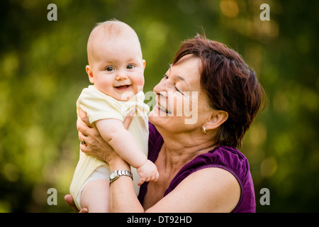 Nonna con il nipote - senior donna mentre tiene il suo nipote outdoor in natura Foto Stock