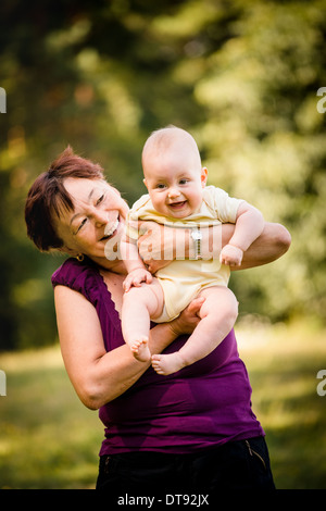 Nonna con il nipote - senior donna mentre tiene il suo nipote outdoor in natura Foto Stock