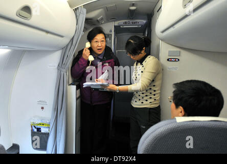 (140213) -- HOTAN, Feb 13, 2014 (Xinhua) -- Tian Wen, vice presidentessa del governo dello Xinjiang Uygur Regione autonoma, lavora su un piano chartered carring soccorritori mentre la voce per il quake-hit Hotan, in Urumqi, capitale del nord-ovest della Cina di Xinjiang Uygur Regione autonoma, Feb 12, 2014. Un 7.3-grandezza terremoto ha colpito la contea di Yutian nella prefettura di Hotan a 17:19 p.m., secondo il terremoto in Cina Centro reti. Un conseguente 5.7-grandezza quake ha colpito la stessa area al 5:24 p.m. ad una profondità di 5 km, seguita da diverse scosse al di sotto di 5-grandezza. Finora non vittime sono state r Foto Stock