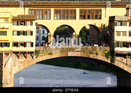 Ponte Vecchio con il tardo pomeriggio la luce solare e la folla di turisti, un solo vogatore sotto il ponte Foto Stock