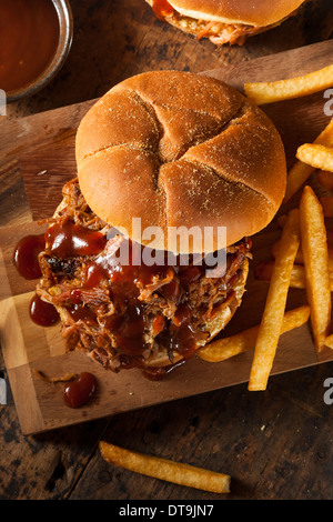 Barbeque tirato Sandwich di maiale con salsa barbecue e patatine fritte Foto Stock