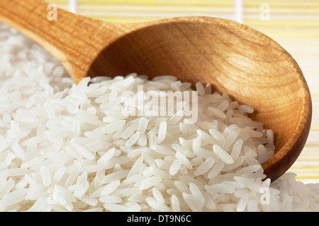 Bianco lungo il riso crudo sul cucchiaio di legno Foto Stock