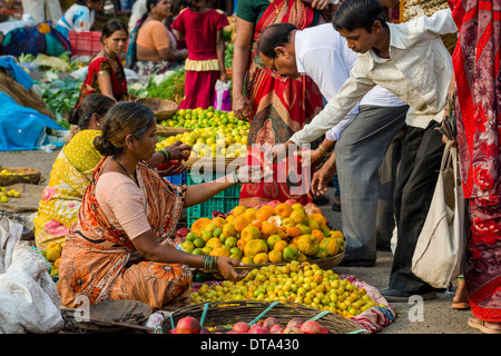 Una donna è la vendita di arance e altri frutti presso il settimanale mercato ortofrutticolo, Nasik, Maharashtra, India Foto Stock