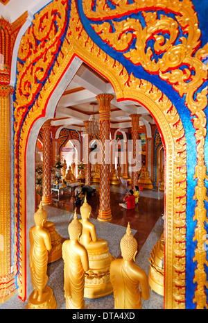 Gate di ornati e Golden Statue di Buddha, Wat Chalong tempio, Phuket, Tailandia Foto Stock