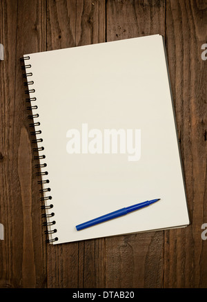 Blank rilegato a spirale scrapbook su un rustico in legno con sfondo spazio copia e penna a piedi del pad. Foto Stock