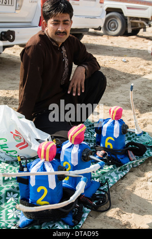 Uomo di vendita piccole robot fantini al camel racing club at Al Marmoum fuori Dubai negli Emirati Arabi Uniti Foto Stock