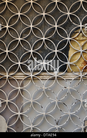 Metallo arrugginito porta con cerchi geometrici motif e vernice in vetro colorato sfondo. Foto Stock