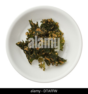 Arrosto di kale chip in un recipiente isolato su sfondo bianco Foto Stock