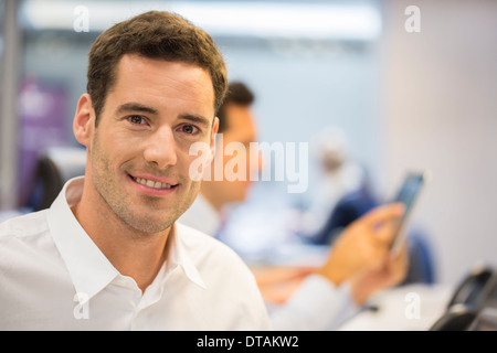 Ritratto di Allegro imprenditore in ufficio, guardando la fotocamera Foto Stock
