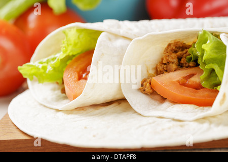 Burrito di manzo con pomodoro e foglia di insalata sul vecchio tavolo in legno in stile rustico Foto Stock