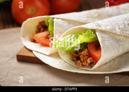 Burrito di manzo con pomodoro e foglia di insalata sul vecchio tavolo in legno in stile rustico Foto Stock