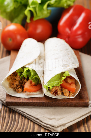 Burrito di manzo con pomodoro e foglia di insalata sul vecchio tavolo in legno in stile rustico Foto Stock