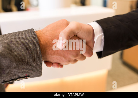 Due imprenditori stringono le mani in office Foto Stock